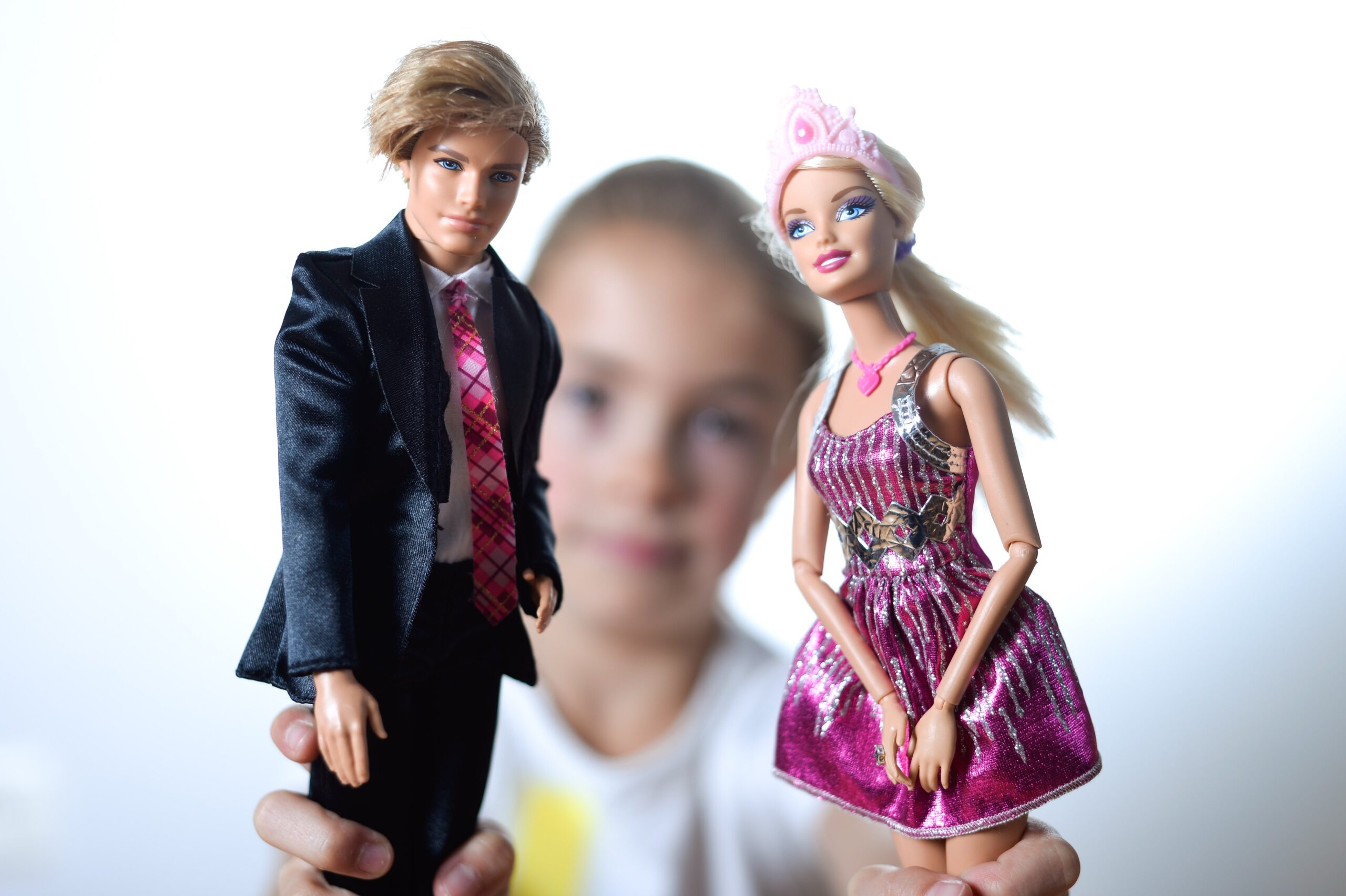 Young girl with Ken and Barbie dolls