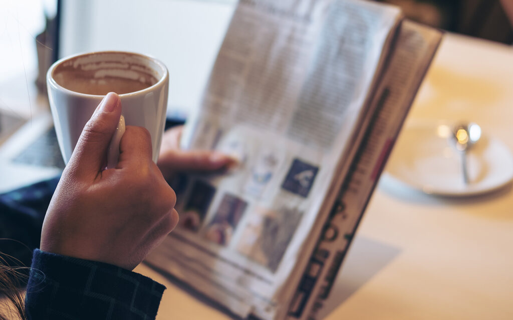Person reading a newspaper in a coffeeshop